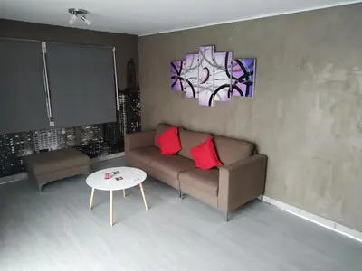 a living room with a couch and a table at Modern Suite, XL balcony, parking in Nicosia