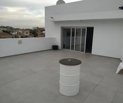 a large white room with a table on a floor at Modern Suite, XL balcony, parking in Nicosia