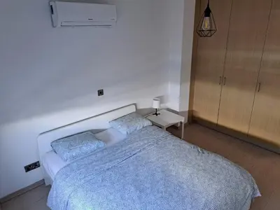 a bedroom with a bed with two blue pillows at Modern Suite, XL balcony, parking in Nicosia