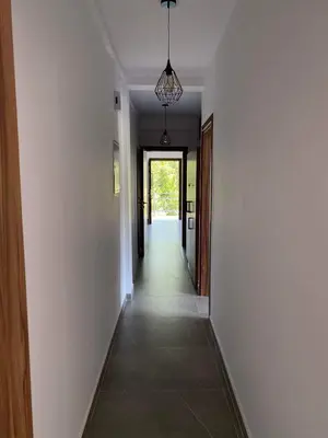 a hallway with white walls and a hallway with a light fixture at Maria's Apartments 1 in Galata
