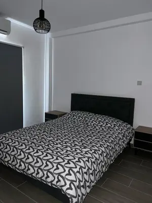 a bedroom with a bed with a black and white comforter at Maria's Apartments 1 in Galata