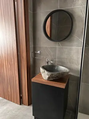 a bathroom with a stone sink and a mirror at Maria's Apartment 2 in Galata