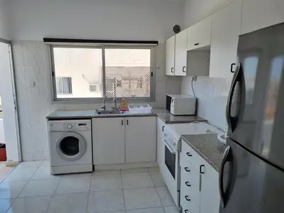 a kitchen with a washing machine and a window at Ikaros Boutique Apartment in Limassol