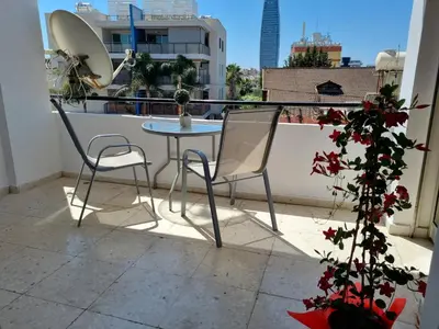 a table and two chairs on a balcony at Ikaros Boutique Apartment in Limassol