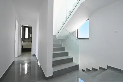 a staircase in a house with white walls and concrete floors at By the Beach Villa 12 in Protaras