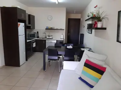 a living room with a white couch and a kitchen at Mythical Sands Resort Ilona Apartment for families in Protaras