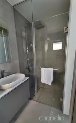 a bathroom with a glass shower with a sink at anemelie in Sotira
