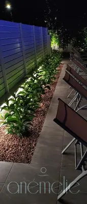 a sidewalk with benches and a fence and plants at anemelie in Sotira