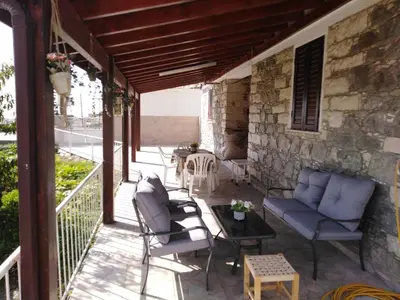 a patio with chairs and a table on a stone wall at Traditional house in pelendri in Limassol