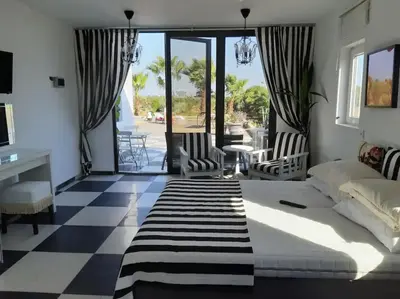 a bedroom with a bed and chairs and a patio at The Pervoli Studio - Pool - Close to Beach in Larnaka