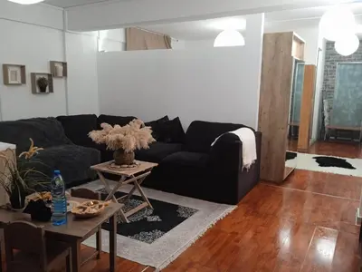 a living room with a black couch and a table at Adorable Cozy Apartment in Aglantzia