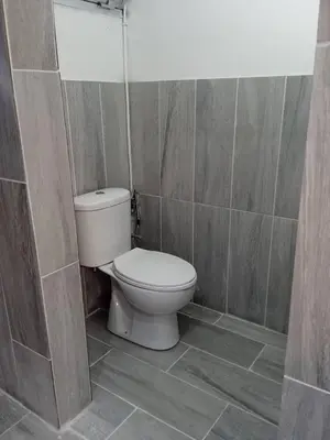 a bathroom with a toilet in a tiled room at Adorable Cozy Apartment in Aglantzia