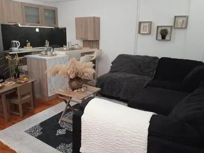 a living room with a couch and a kitchen at Adorable Cozy Apartment in Aglantzia