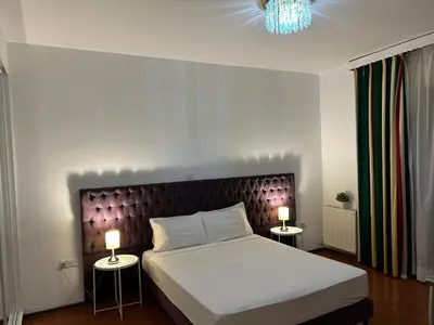 a bedroom with a large bed with two lamps at St Elena Boutique Residence in Larnaka