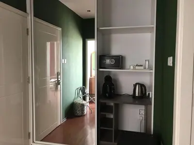 a room with green walls and a door to a kitchen at St Elena Boutique Residence in Larnaka