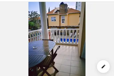 a balcony with a table and a house in the background at St Elena Boutique Residence in Larnaka