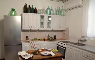 a kitchen with glass bottles on top of the cabinets at Ample Places in Pano Lefkara
