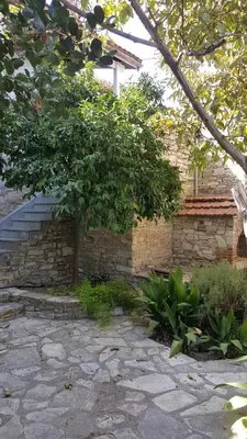 a brick building with a tree and a stone walkway at Ample Places in Pano Lefkara