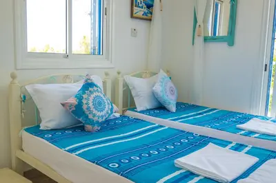 a bedroom with two beds with blue and white pillows at Greek Island Style 2 bedroom Villa with Pool next to the Sea in Larnaka