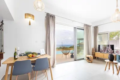 a dining room with a table and a view of the ocean at Villa Pacy in Ayios Theodhoros