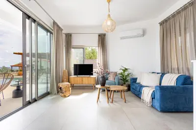 a living room with a blue couch and a tv at Villa Pacy in Ayios Theodhoros