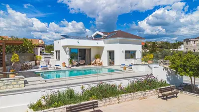 a villa with a swimming pool and a house at Villa Pacy in Ayios Theodhoros