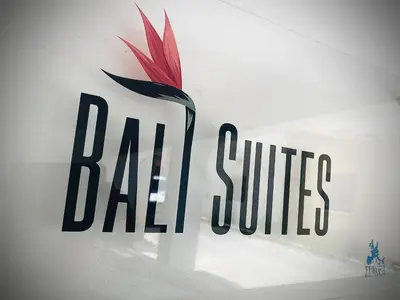 a sign on a wall with a red and black logo at BALI SUITES 404 in Larnaka