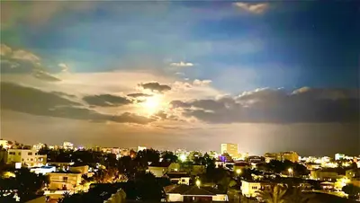 a view of a city with the sun setting at BALI SUITES 404 in Larnaka