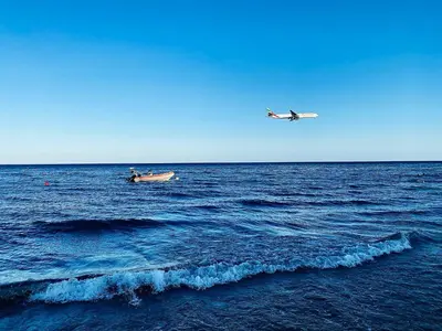 a small boat and a plane in the ocean at BALI SUITES 505 in Larnaka
