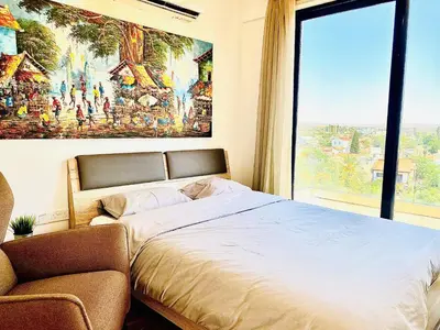 a bedroom with a bed and a large window at BALI SUITES 505 in Larnaka