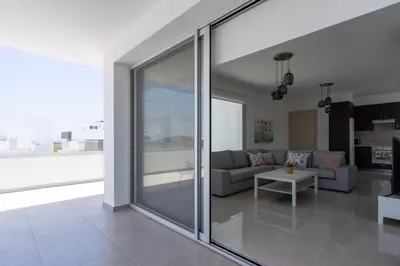 a living room with a sliding glass door at Harmonia 2-BR Apt in Livadia in Larnaka