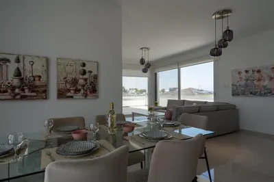 a dining room with a glass table and chairs at Harmonia 2-BR Apt in Livadia in Larnaka
