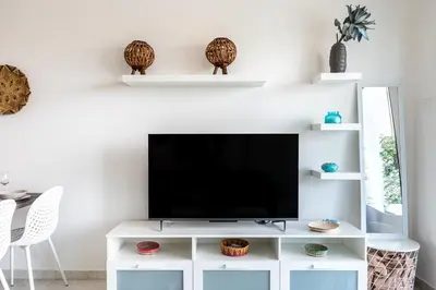 a living room with a tv on a white entertainment center at Bonne Heure 1-BR Apt in Larnaca in Larnaka