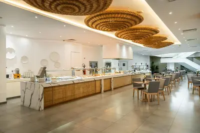a restaurant with tables and chairs and a bar at MARGADINA HOTEL in Ayia Napa