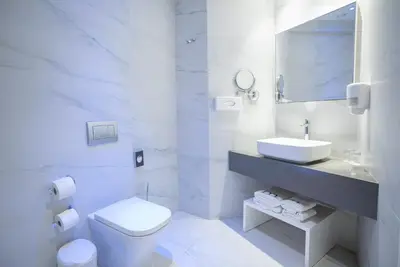 a white bathroom with a sink and a toilet at MARGADINA HOTEL in Ayia Napa