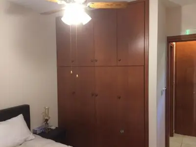 a bedroom with a large wooden cabinet next to a bed at AYIOS NICOLAOS RIVER PARK in Perapedhi
