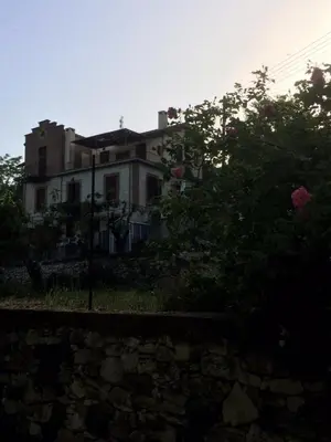 a house on a hill with roses in front of it at AYIOS NICOLAOS RIVER PARK in Perapedhi
