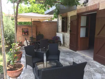 a patio with a table and chairs and an umbrella at AYIOS NICOLAOS RIVER PARK in Perapedhi