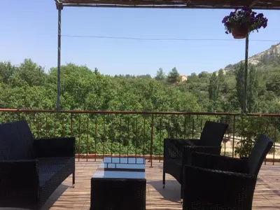 a patio with chairs and a table on a deck at AYIOS NICOLAOS RIVER PARK in Perapedhi