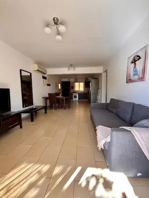 a living room with a couch and a dining room at 2 bedroom with private garden, walk to Nissi Beach, communal swimming pool in Ayia Napa