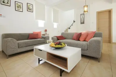a living room with couches and a bowl of fruit on a table at Villa Danata in Protaras