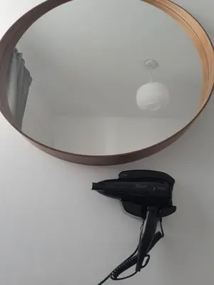 a phone hanging under a mirror on a wall at Beautiful apartment near beach in Larnaca in Scala