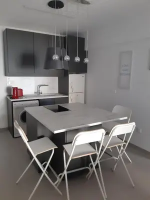 a kitchen with a table with two chairs and a sink at Beautiful apartment near beach in Larnaca in Scala