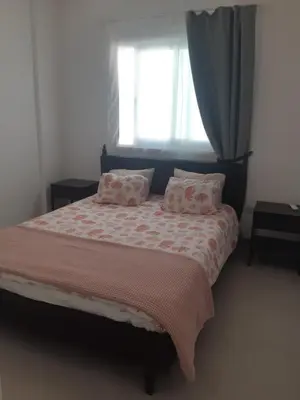 a bedroom with a bed with pink sheets and a window at Beautiful apartment near beach in Larnaca in Scala