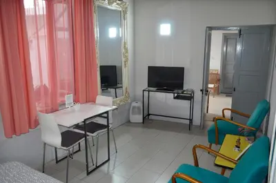 a living room with a table and chairs and a mirror at St. Lazaros Studios in Larnaka