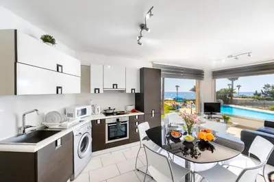 a kitchen and living room with a table and a dining room at Fig Tree bay Apartment 103 in Protaras