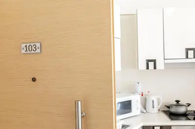 a door in a kitchen with a clock on it at Fig Tree bay Apartment 103 in Protaras
