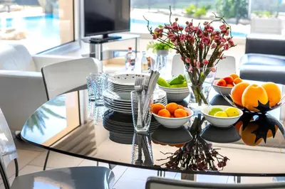 a table with plates and bowls of fruit on it at Fig Tree bay Apartment 103 in Protaras