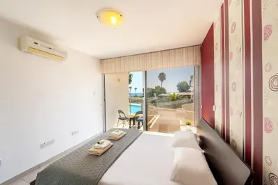a bedroom with a bed with a view of the ocean at Fig Tree bay Apartment 103 in Protaras