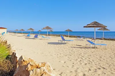 a group of chairs and umbrellas on a beach at Villa Louisa in Ayia Napa